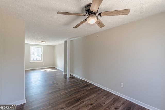 spare room with dark wood-style floors, ceiling fan, baseboards, and a textured ceiling