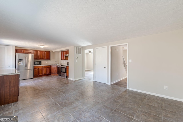 kitchen featuring stainless steel appliances, a ceiling fan, visible vents, light countertops, and brown cabinets