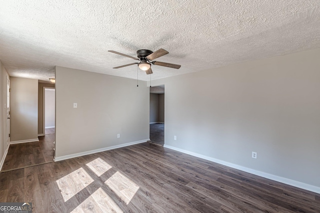 unfurnished room featuring dark wood-style floors, ceiling fan, a textured ceiling, and baseboards