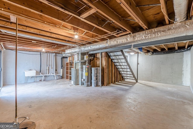 unfinished below grade area featuring stairs, gas water heater, and a sink