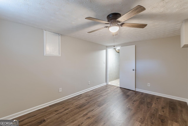 unfurnished bedroom with a ceiling fan, a textured ceiling, baseboards, and dark wood-type flooring