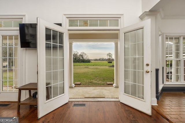 entryway featuring ornamental molding, dark wood finished floors, and visible vents