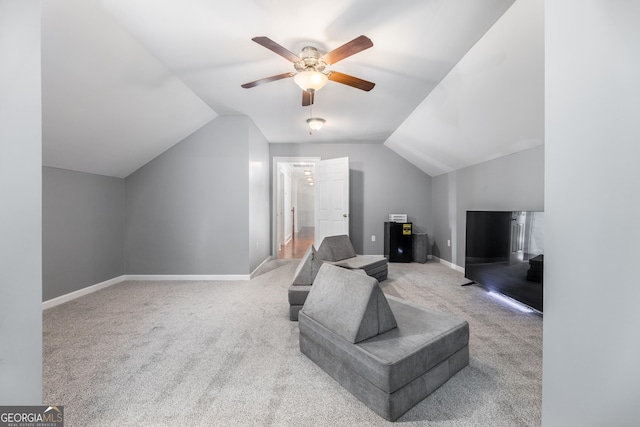 carpeted living room with vaulted ceiling, baseboards, and ceiling fan