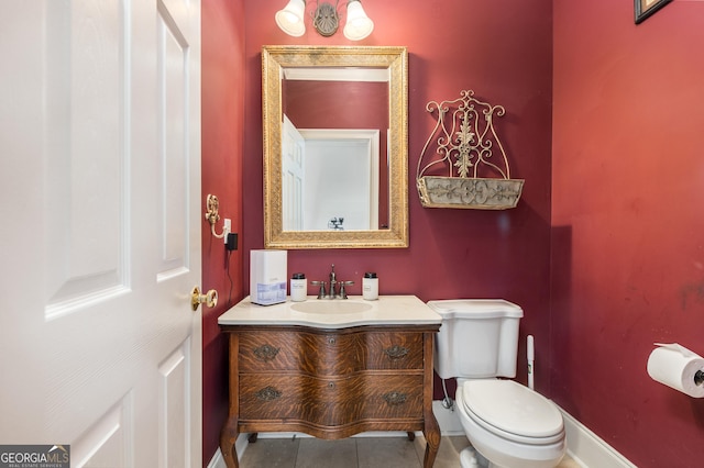 bathroom featuring baseboards, vanity, toilet, and tile patterned floors