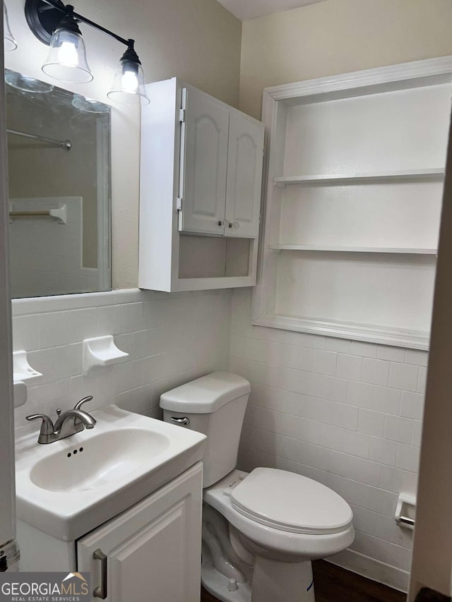 bathroom featuring tile walls, vanity, and toilet