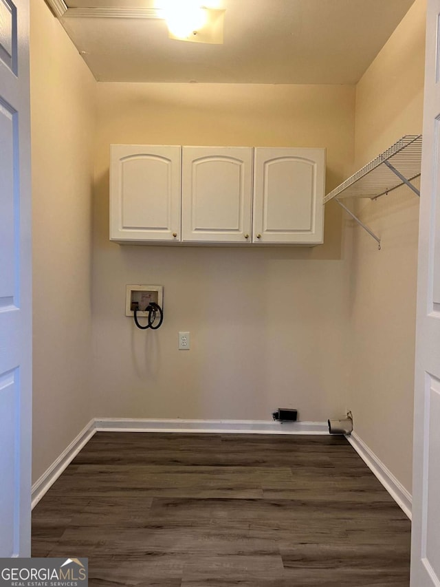 laundry room with hookup for a washing machine, baseboards, dark wood-type flooring, and cabinet space