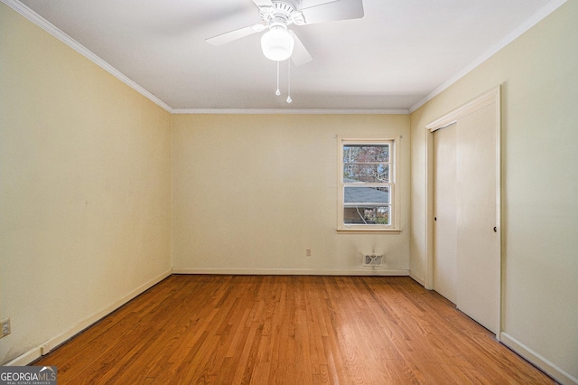 unfurnished bedroom with ornamental molding, light wood-type flooring, a closet, and baseboards