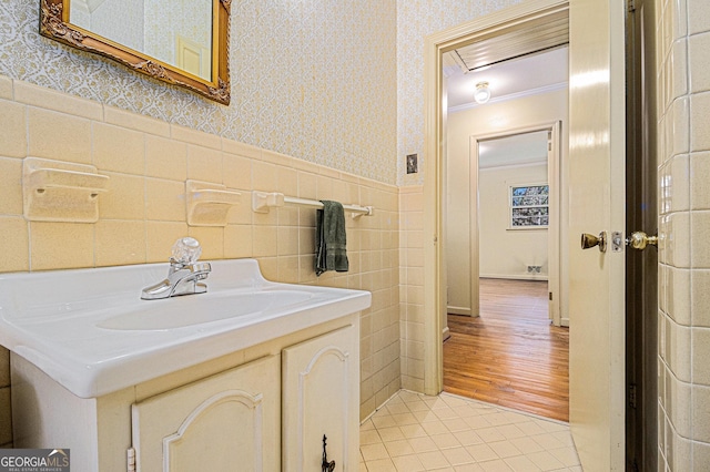 bathroom featuring tile patterned flooring, a wainscoted wall, vanity, and wallpapered walls