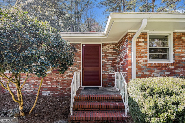 doorway to property featuring brick siding