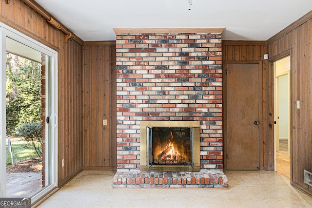 unfurnished living room with a fireplace and wooden walls