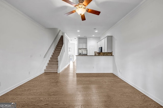 unfurnished living room featuring dark wood-style floors, recessed lighting, stairway, ornamental molding, and baseboards