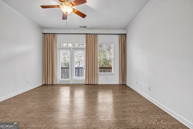 spare room with visible vents, crown molding, baseboards, and wood finished floors