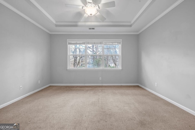 empty room featuring carpet floors, a raised ceiling, visible vents, and baseboards