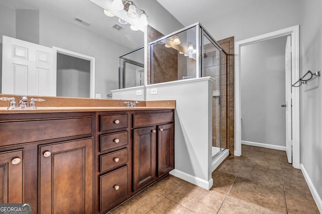 full bath featuring tile patterned flooring, visible vents, a shower stall, and double vanity