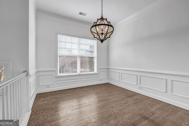 unfurnished room featuring ornamental molding, dark wood-type flooring, visible vents, and an inviting chandelier