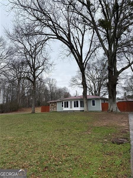 view of front of home featuring fence and a front yard