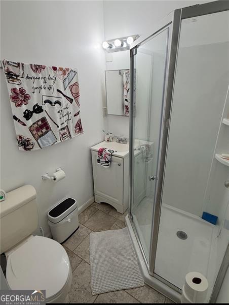 full bath with a stall shower, vanity, and toilet