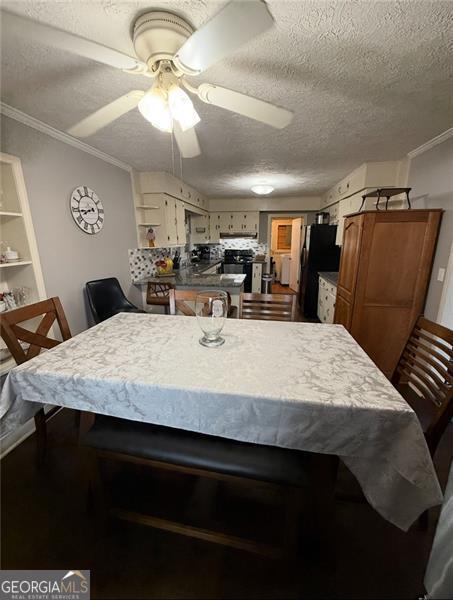 dining room featuring ceiling fan, ornamental molding, and a textured ceiling