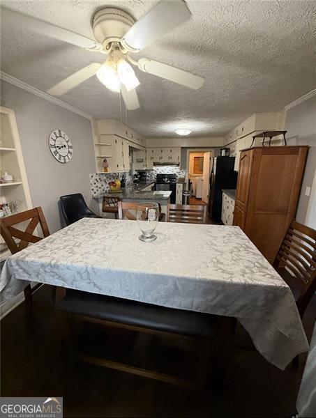 dining area with ornamental molding, ceiling fan, and a textured ceiling