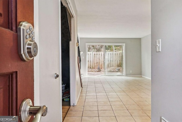 corridor with light tile patterned floors and baseboards