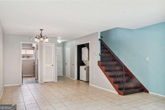 spare room with stairway, light tile patterned flooring, baseboards, and a chandelier