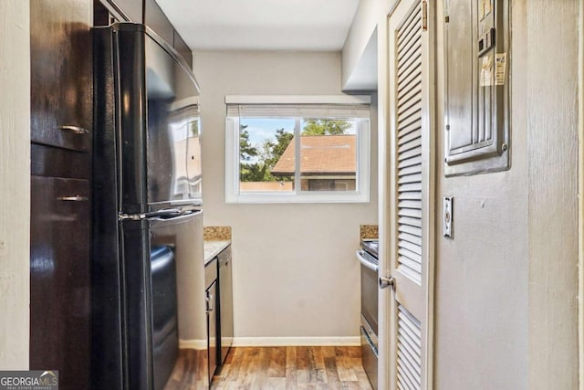 kitchen featuring wood finished floors, baseboards, and appliances with stainless steel finishes