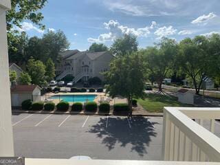 uncovered parking lot featuring an outdoor pool