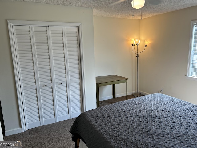 bedroom featuring a closet, baseboards, dark colored carpet, and a textured ceiling