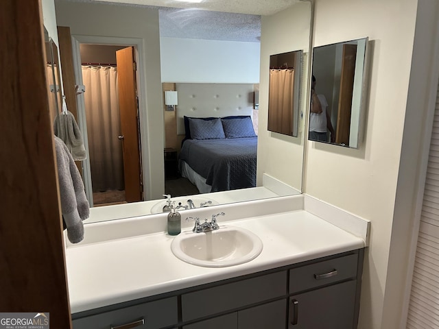 bathroom featuring connected bathroom, a textured ceiling, and vanity