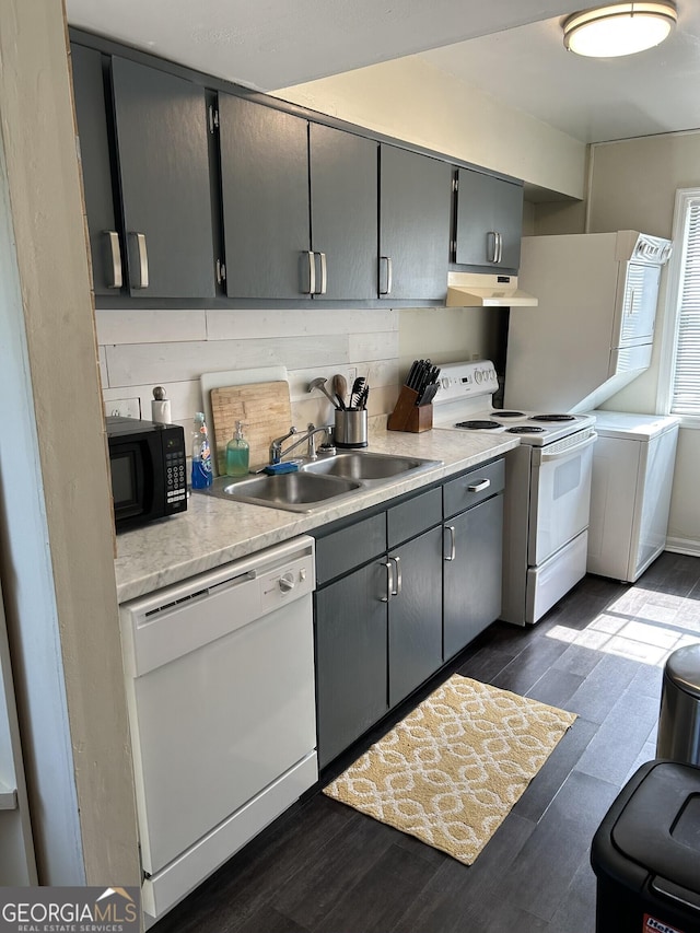 kitchen featuring light countertops, gray cabinetry, a sink, white appliances, and under cabinet range hood