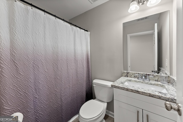 bathroom with baseboards, visible vents, vanity, and toilet