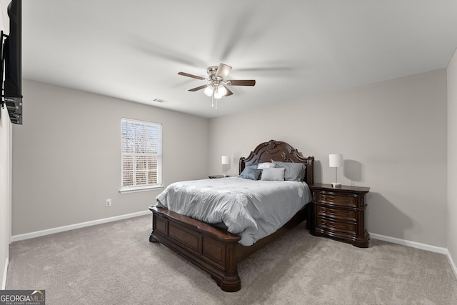 bedroom with a ceiling fan, light colored carpet, visible vents, and baseboards