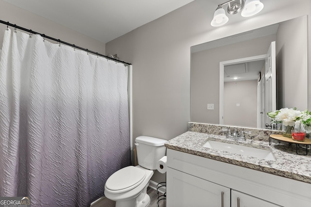 bathroom with toilet, vanity, and baseboards