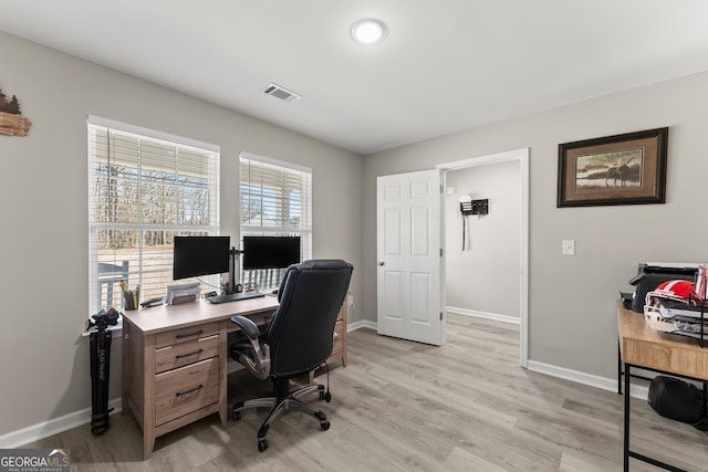 office space with baseboards, visible vents, and light wood finished floors