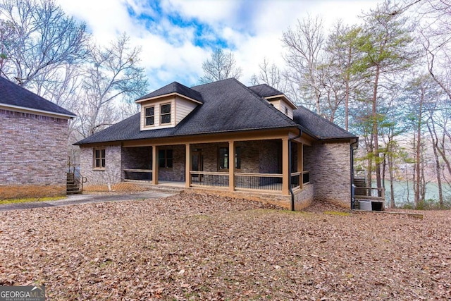 view of front facade featuring stone siding and a shingled roof