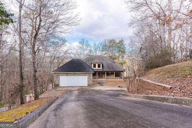 view of front facade featuring an attached garage, aphalt driveway, and brick siding