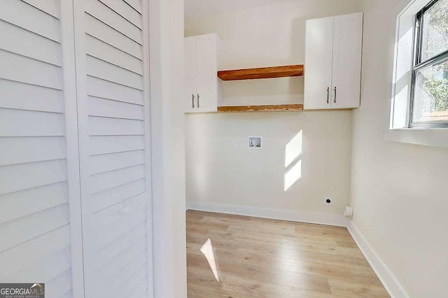 washroom with hookup for an electric dryer, washer hookup, baseboards, cabinet space, and light wood finished floors