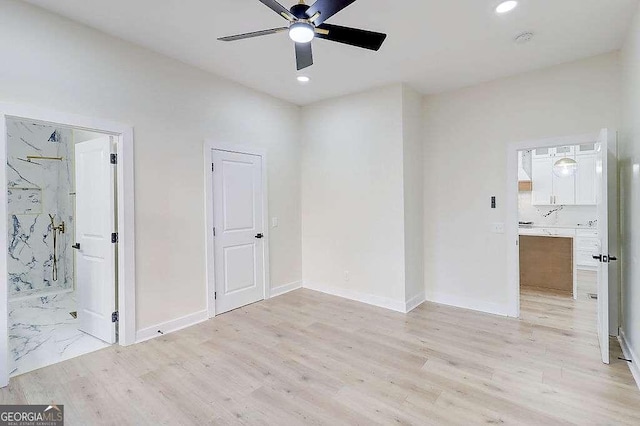 unfurnished bedroom with ensuite bathroom, recessed lighting, light wood-type flooring, and baseboards