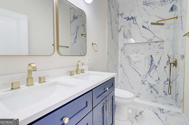 bathroom featuring toilet, double vanity, a sink, and a marble finish shower