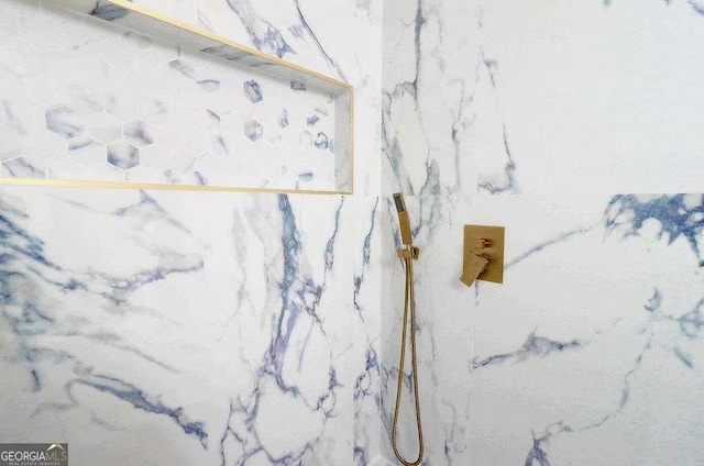 room details featuring a marble finish shower