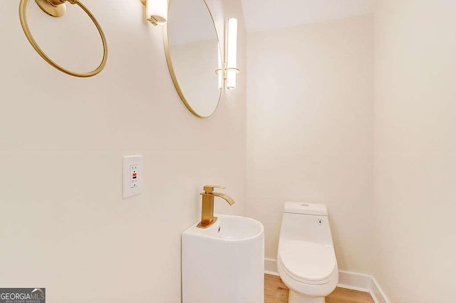 bathroom featuring baseboards, toilet, and wood finished floors