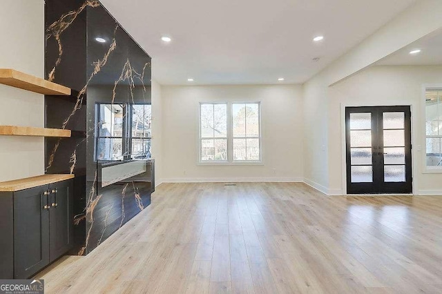 interior space featuring baseboards, french doors, recessed lighting, and light wood-style floors