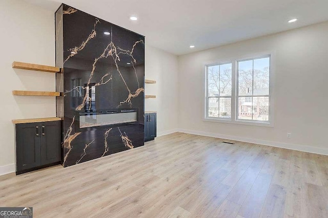 living area featuring baseboards, recessed lighting, visible vents, and light wood-style floors