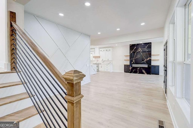 hallway with stairs, light wood-type flooring, visible vents, and recessed lighting