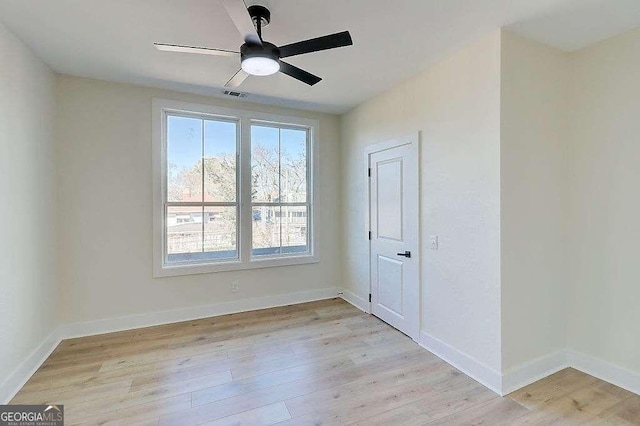 empty room with light wood-type flooring, visible vents, baseboards, and a ceiling fan