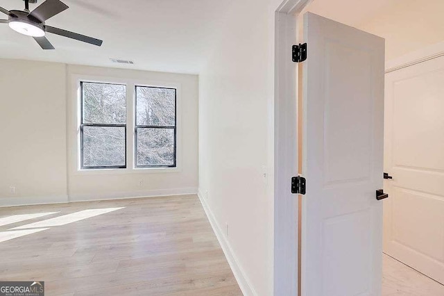 interior space with light wood-type flooring, visible vents, and baseboards