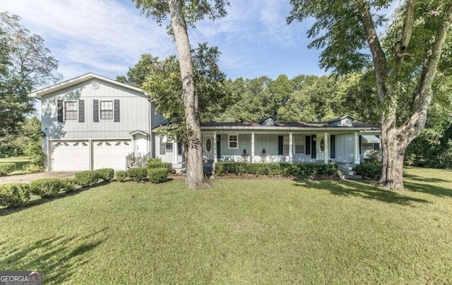 tri-level home with concrete driveway, a front lawn, a porch, and an attached garage