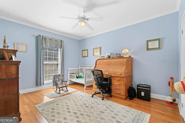 home office with light wood-style floors, baseboards, a ceiling fan, and ornamental molding