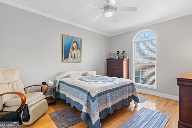 bedroom featuring ornamental molding, a ceiling fan, light wood-style flooring, and baseboards