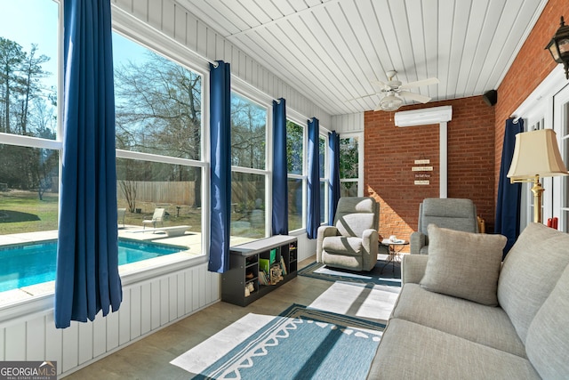 sunroom with a ceiling fan and a wall mounted AC